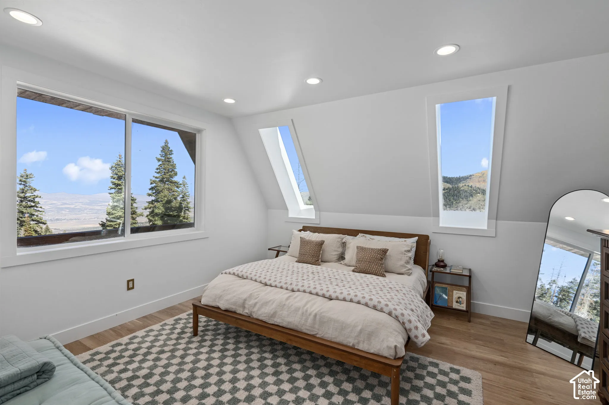 Bedroom with light wood-style floors, multiple windows, and recessed lighting