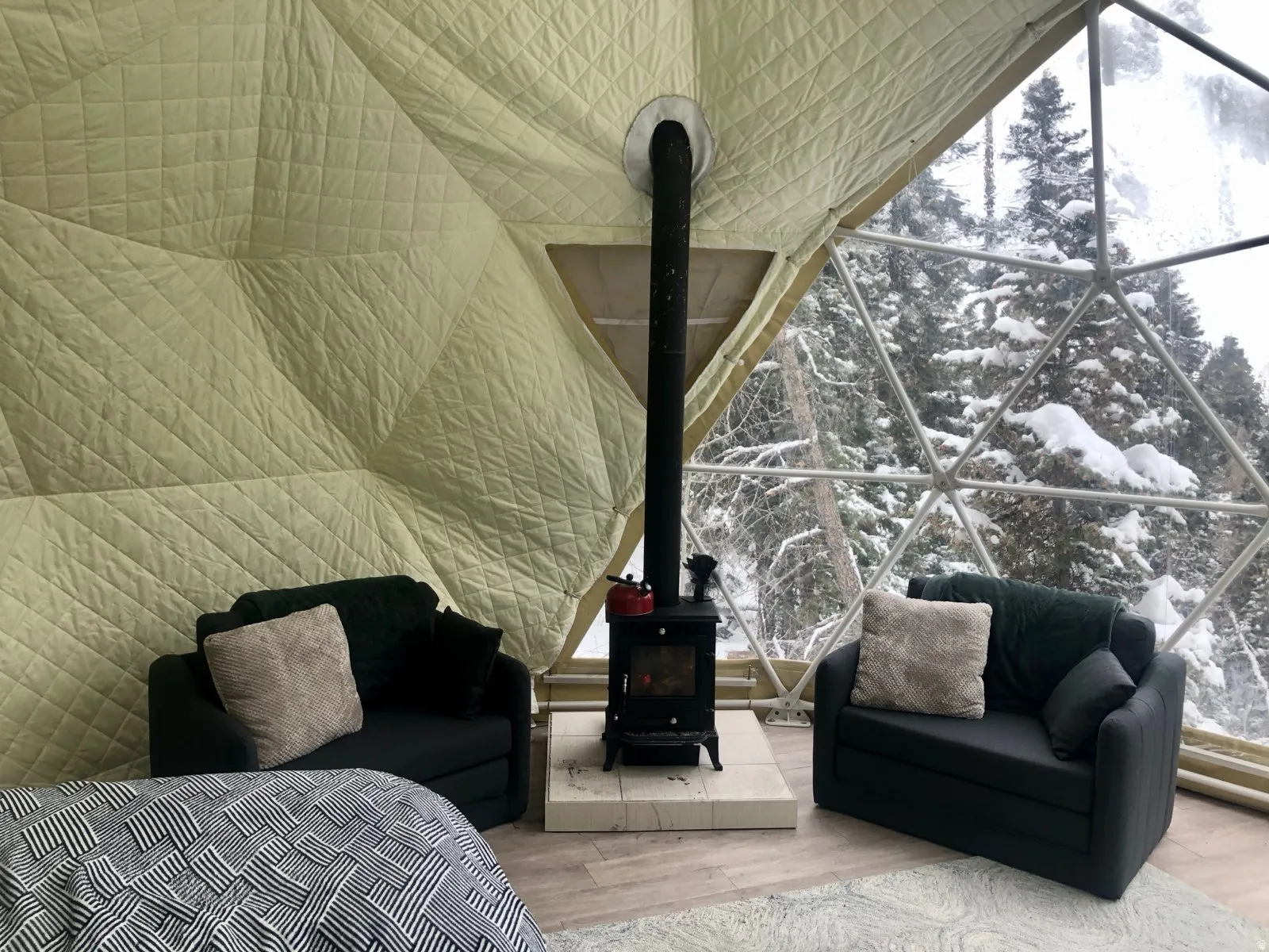 Bedroom featuring wood finished floors, a wood stove, and floor to ceiling windows