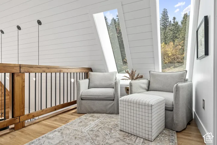 Sitting room with light wood-type flooring and wooden walls