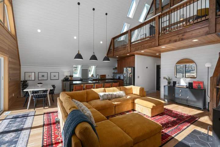 Living room featuring wooden walls, light wood-style flooring, recessed lighting, and a vaulted wood ceiling