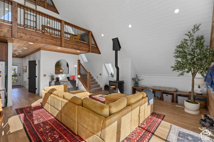 Living room with recessed lighting, wood finished floors, a vaulted wood ceiling, and a wood stove