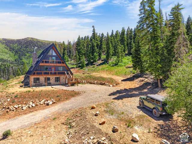 A-frame property with stone veneer lower level, dark siding, and multiple balconies