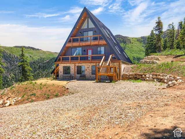 A-frame exterior featuring a stone base and wood-paneled upper levels
