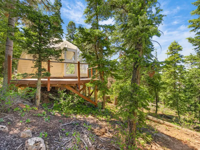Elevated yurt structure with a wood-finish deck and railing