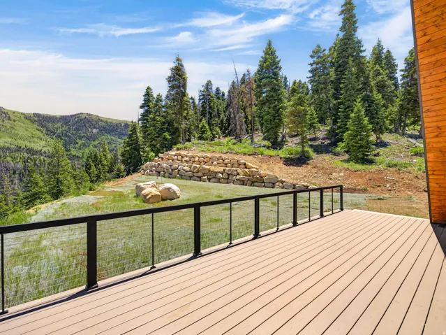 Expansive wood-finish deck with a black metal and cable railing system