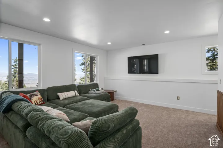 Carpeted living area with recessed lighting and baseboards