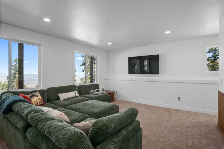Carpeted living area with recessed lighting and baseboards