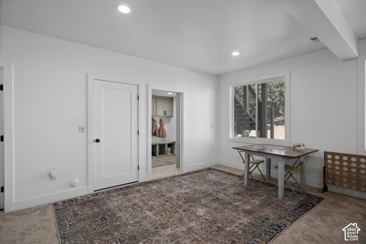 Home office with dark carpet and recessed lighting