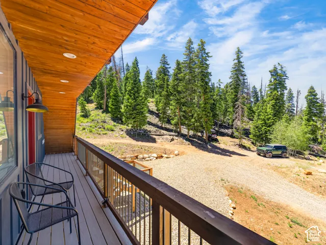 Exterior deck featuring wood-finish flooring, a dark wood-finish railing with metal balusters, and a natural wood-finish ceiling with recessed lighting