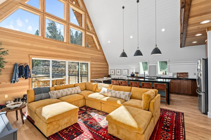 Living area with light wood finished floors, wood walls, recessed lighting, and a high wood ceiling