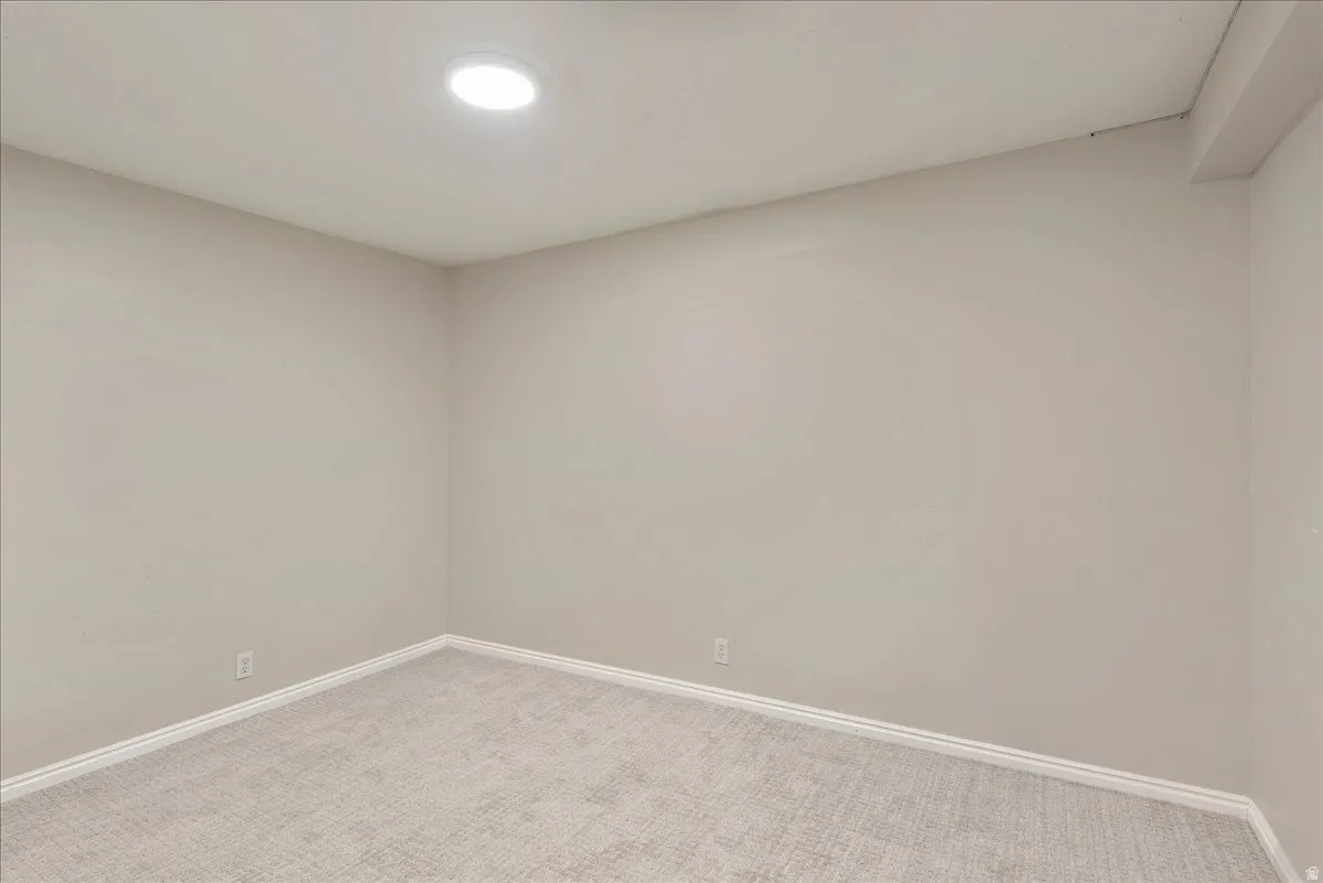 Unfurnished room with light carpet and baseboards