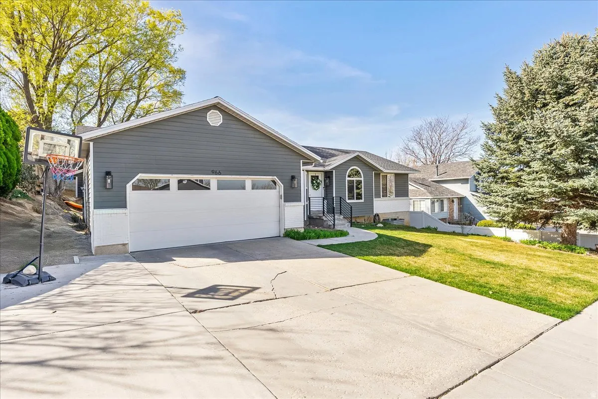 Ranch-style home with a front yard, driveway, and an attached garage