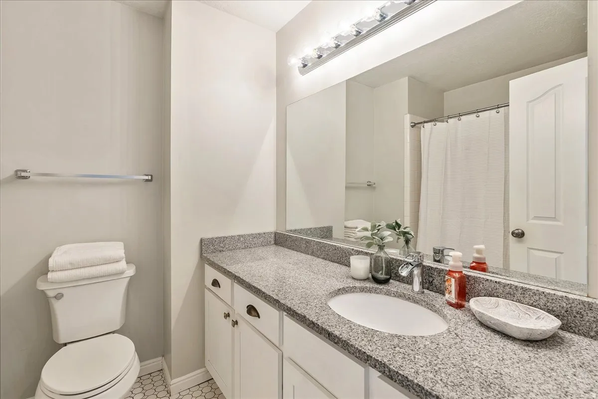 Bathroom with a shower with curtain and vanity