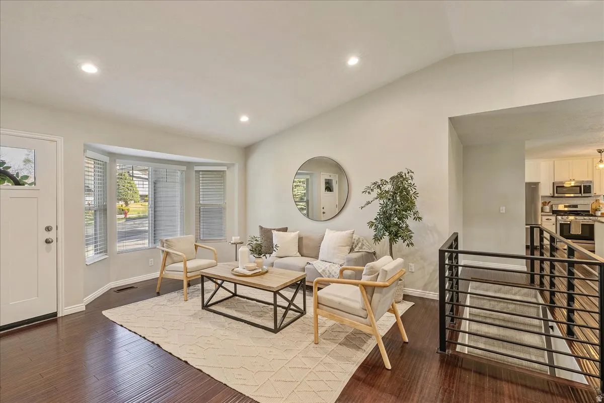 Living area with lofted ceiling, dark wood finished floors, and recessed lighting