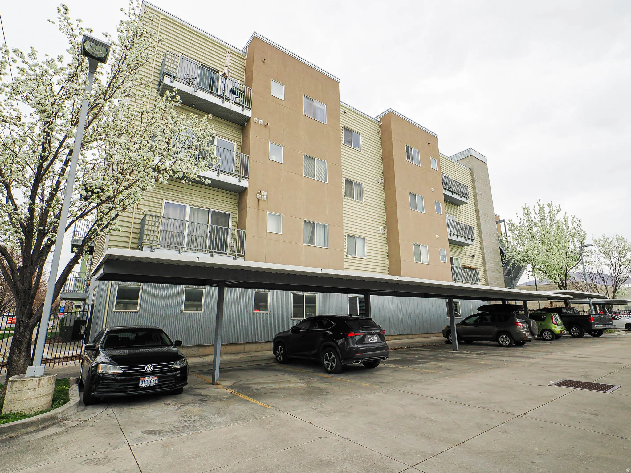View of apartment building / complex featuring covered parking