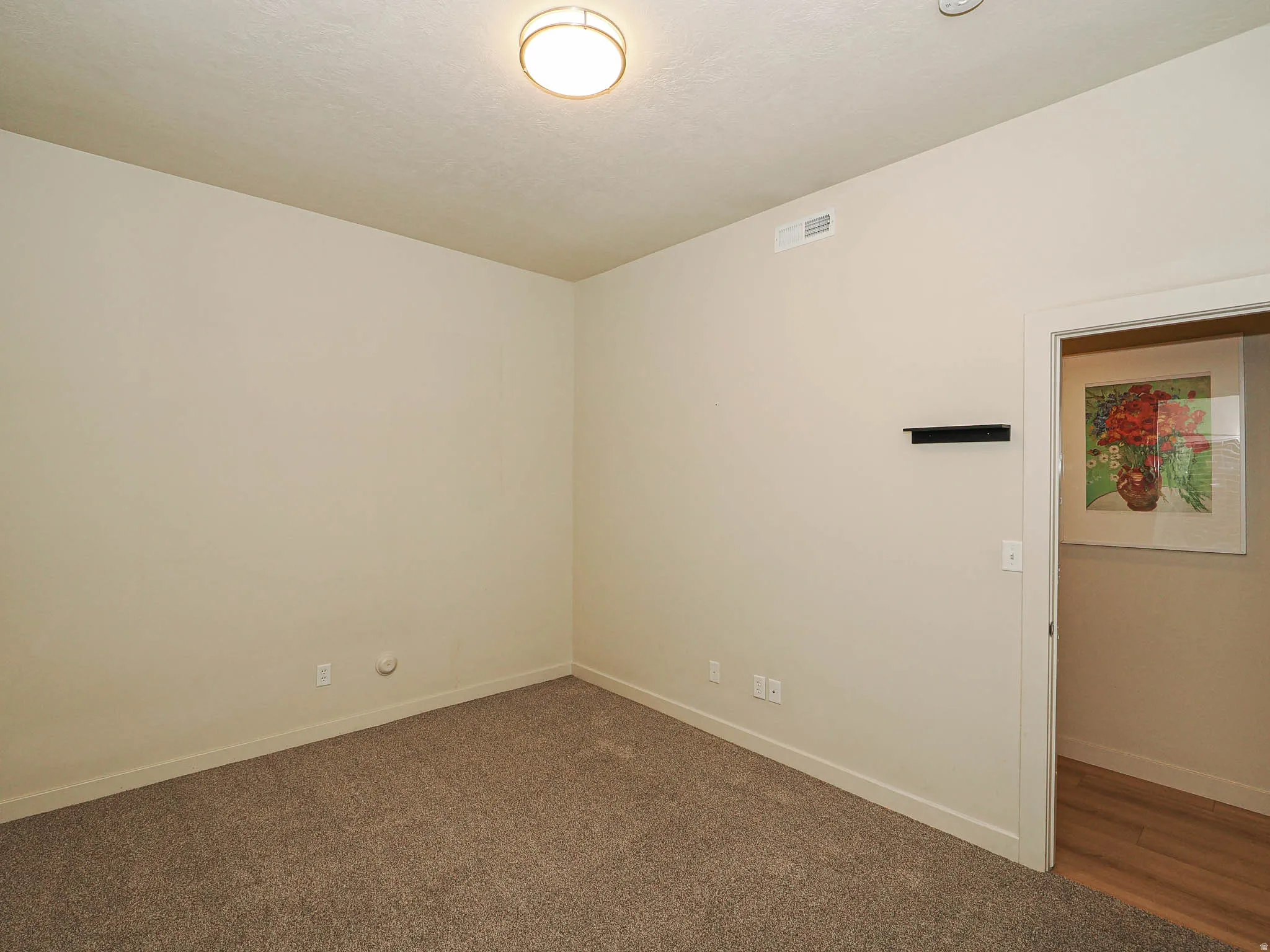 Empty room featuring dark carpet and baseboards