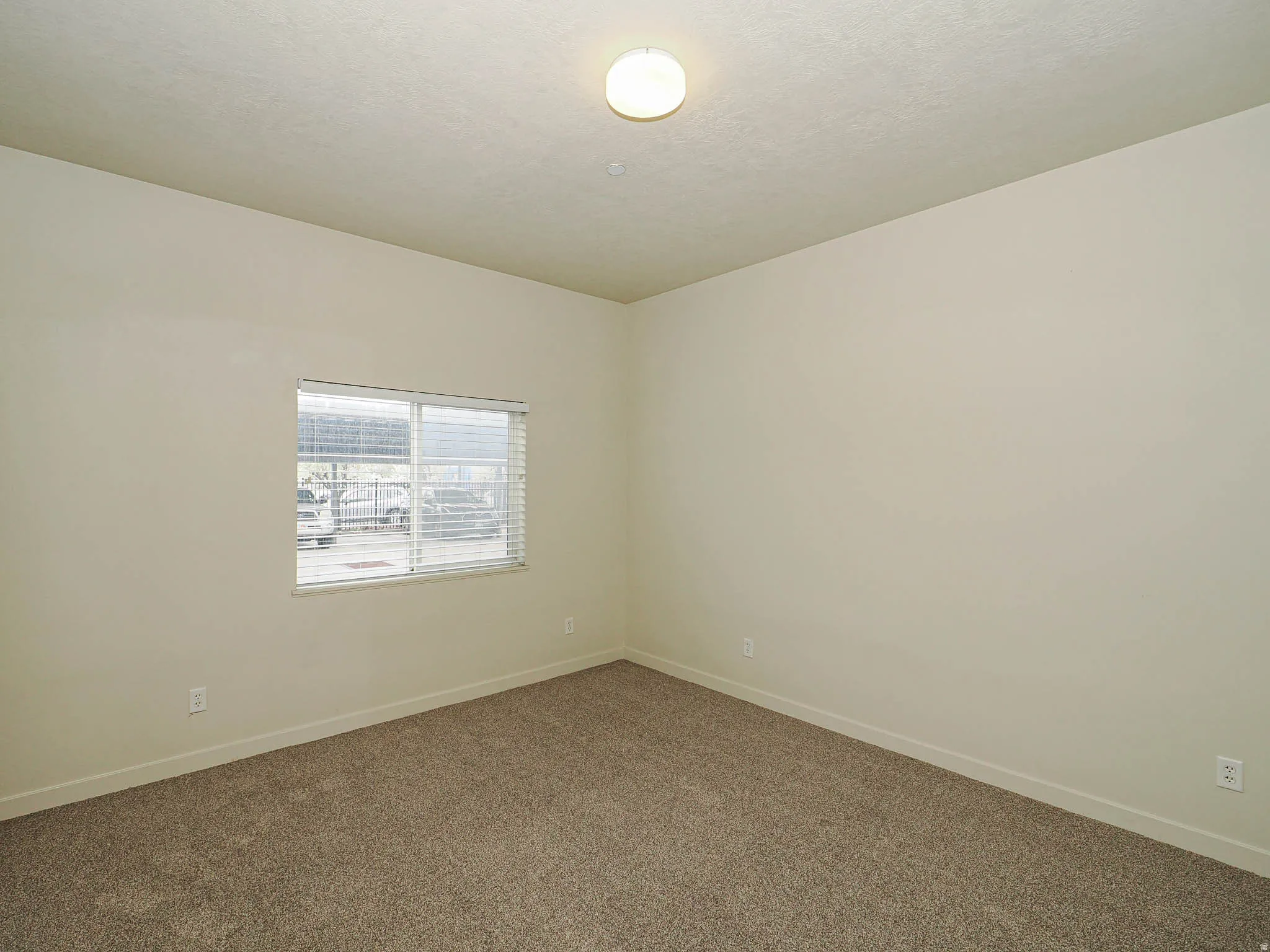 Empty room featuring baseboards and dark colored carpet