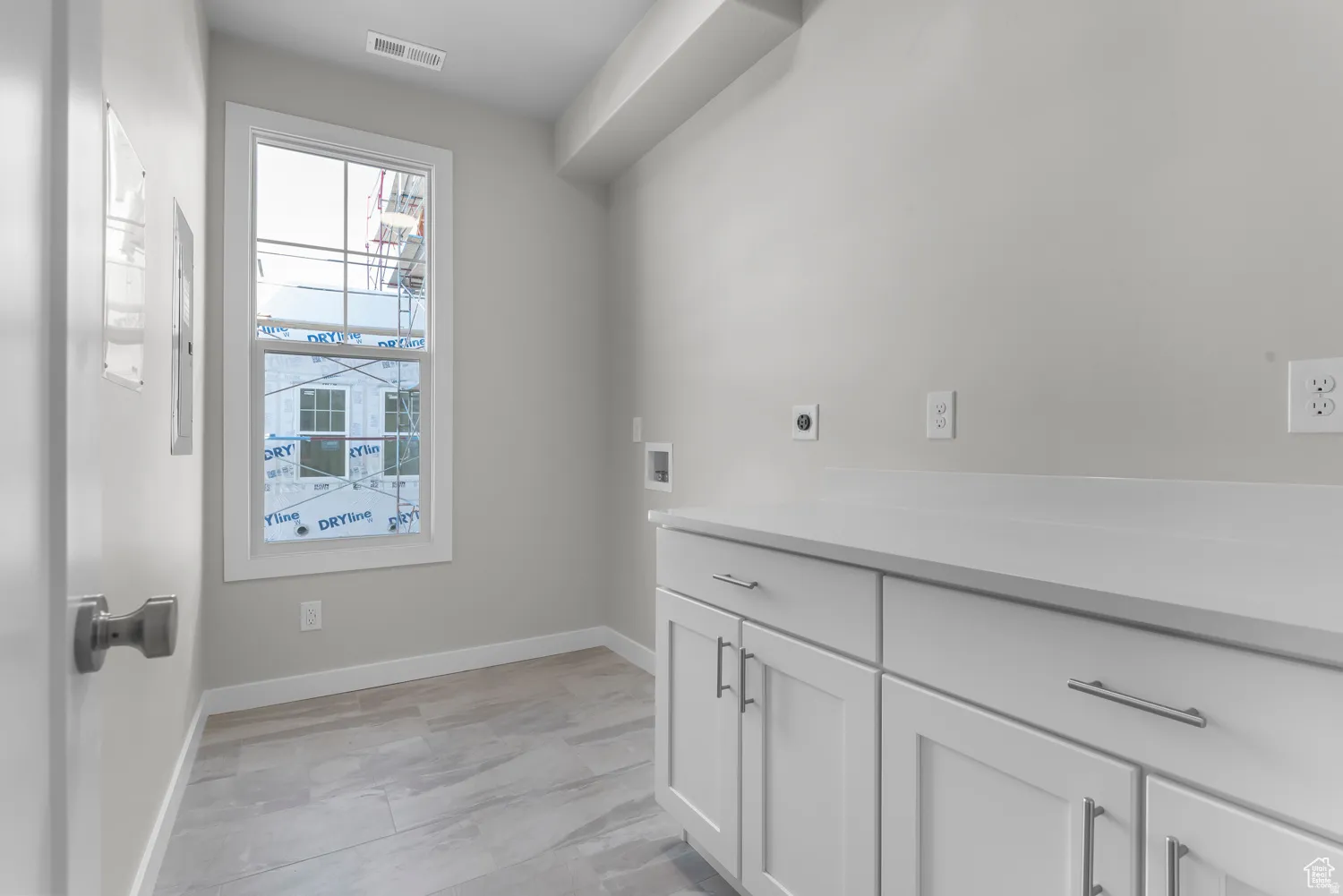 Laundry room with cabinet space, hookup for an electric dryer, and washer hookup