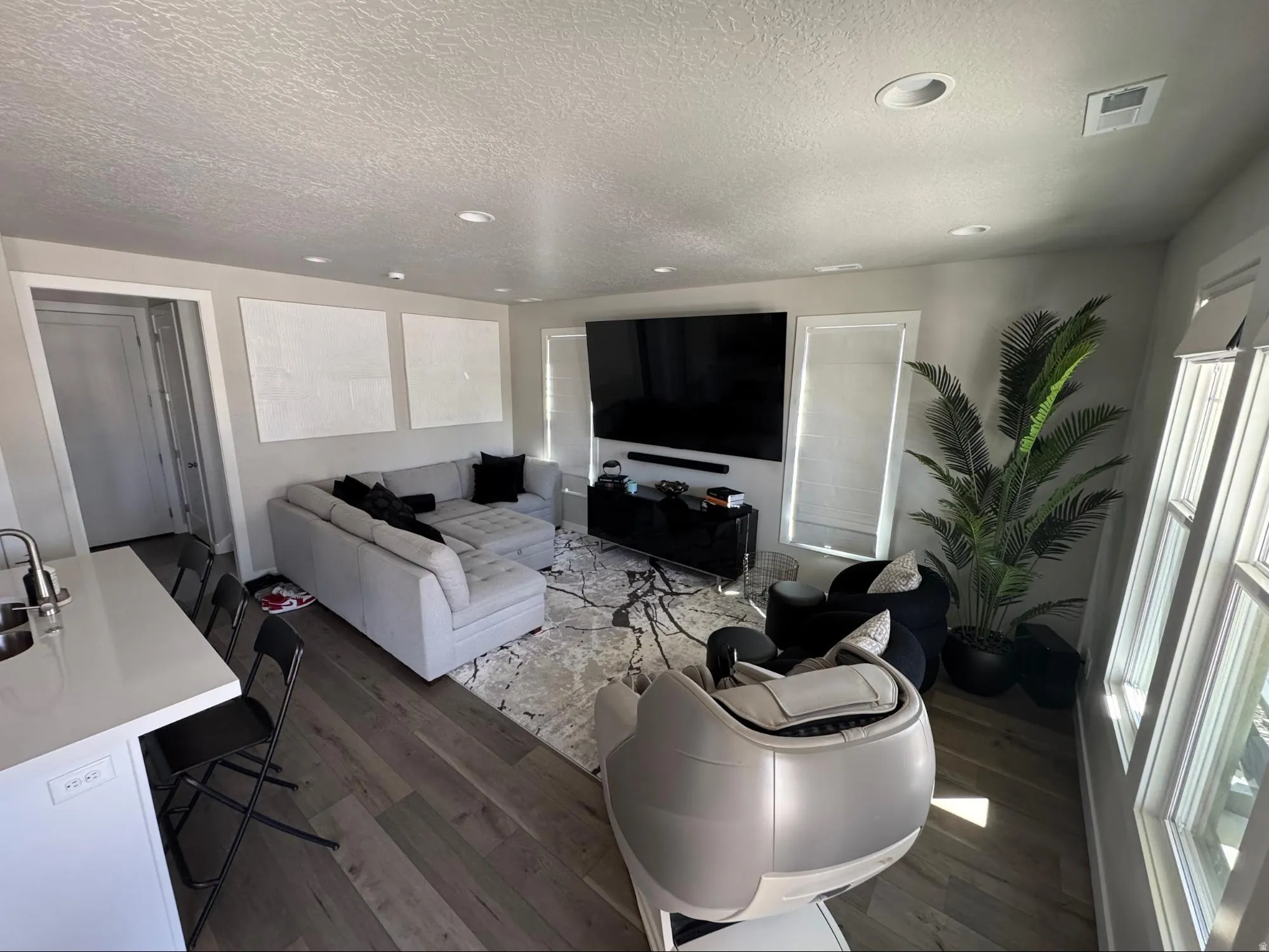 Living room with dark wood-type flooring, a textured ceiling, and recessed lighting