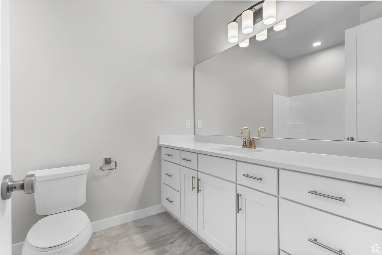 Bathroom featuring vanity, light marble finish floors, and recessed lighting