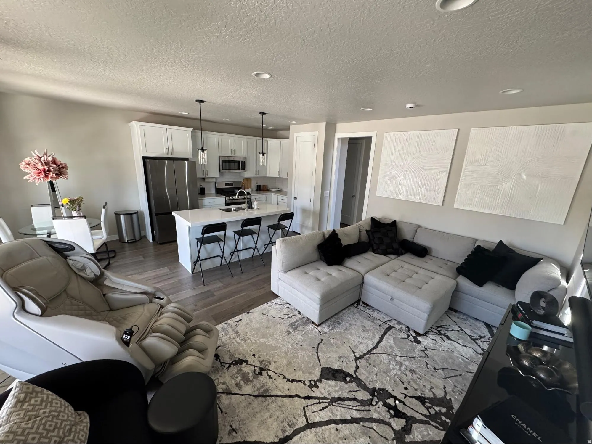 Living room with dark wood-type flooring, a textured ceiling, and recessed lighting