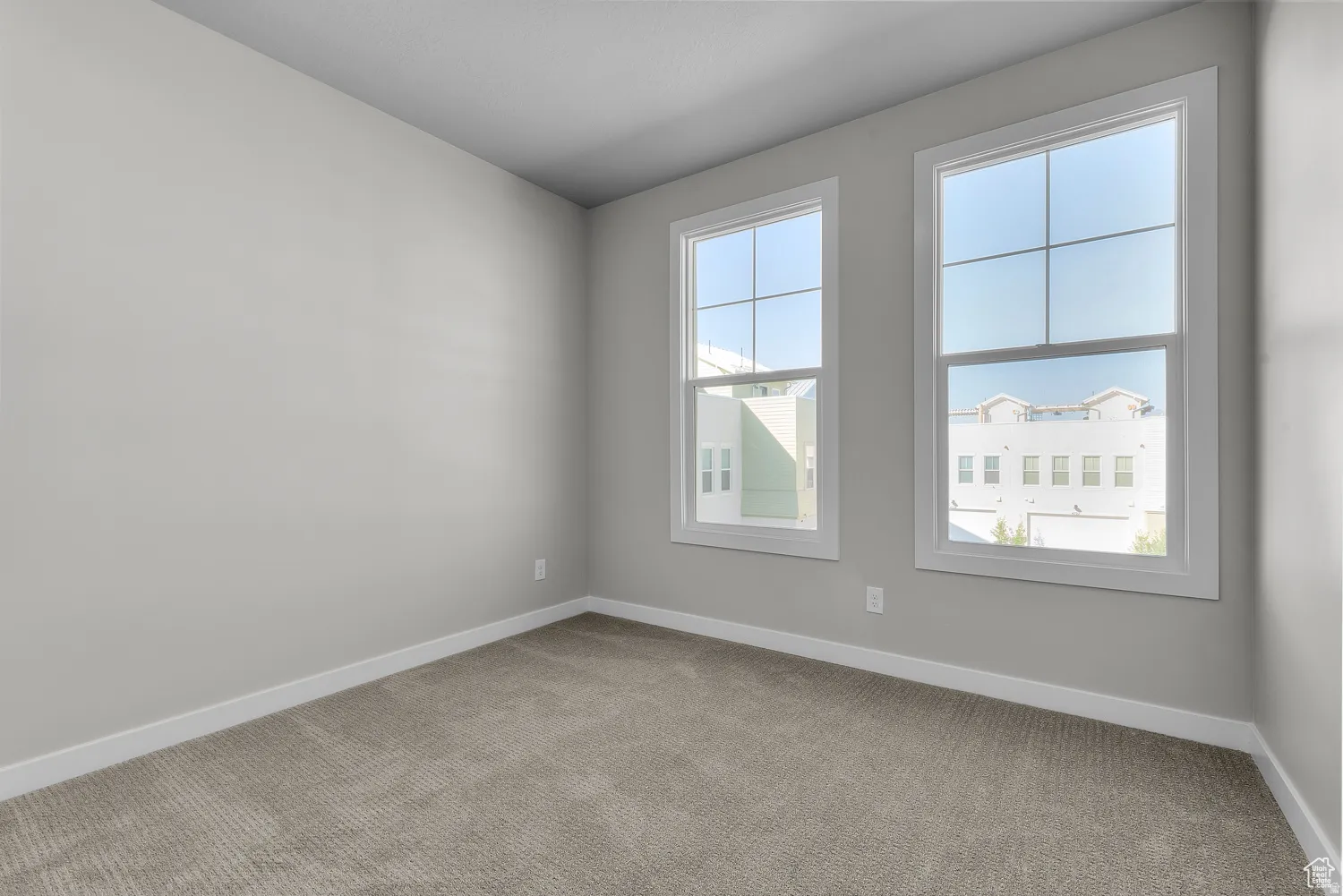 Spare room featuring baseboards and light carpet