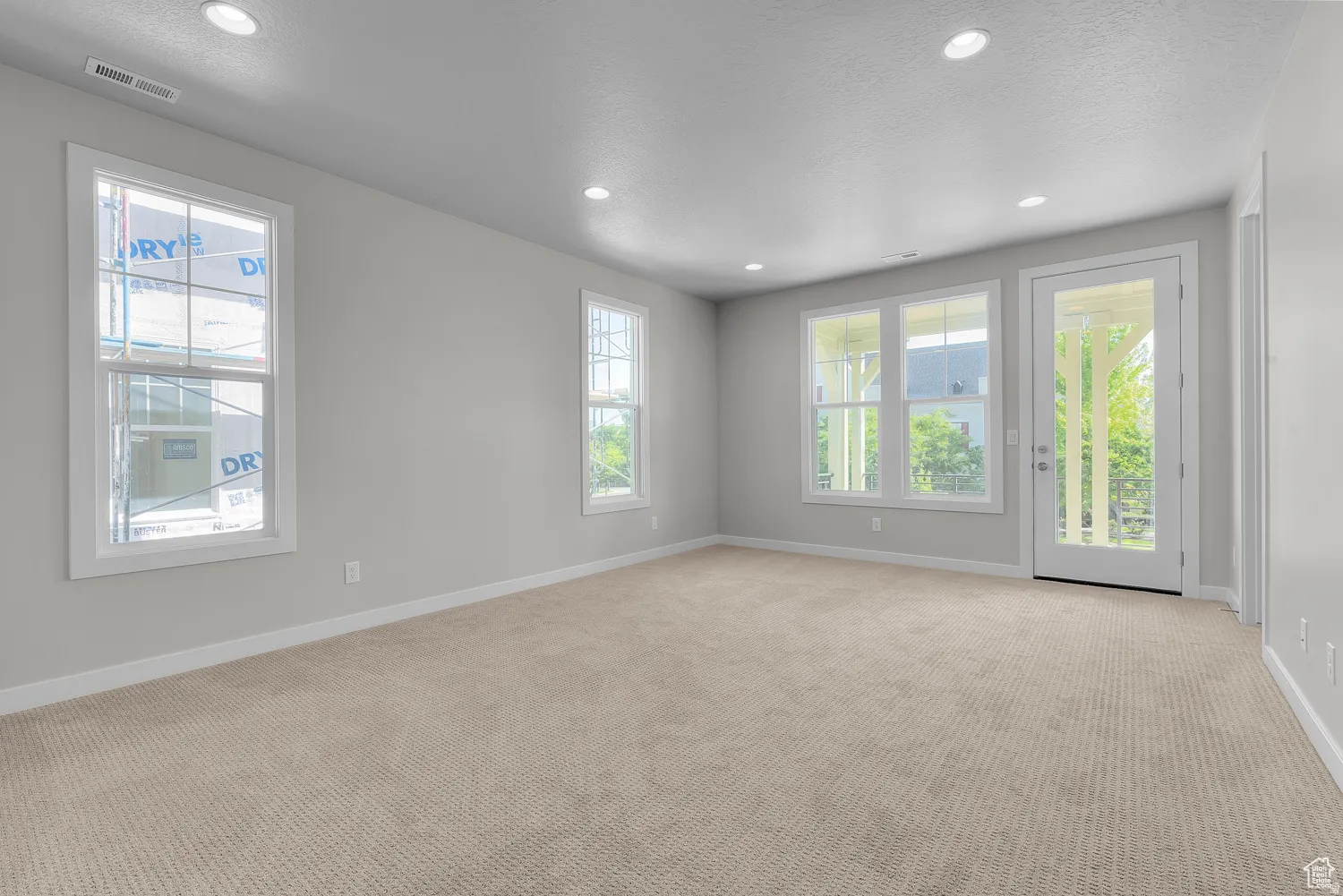 Empty room featuring recessed lighting and light colored carpet