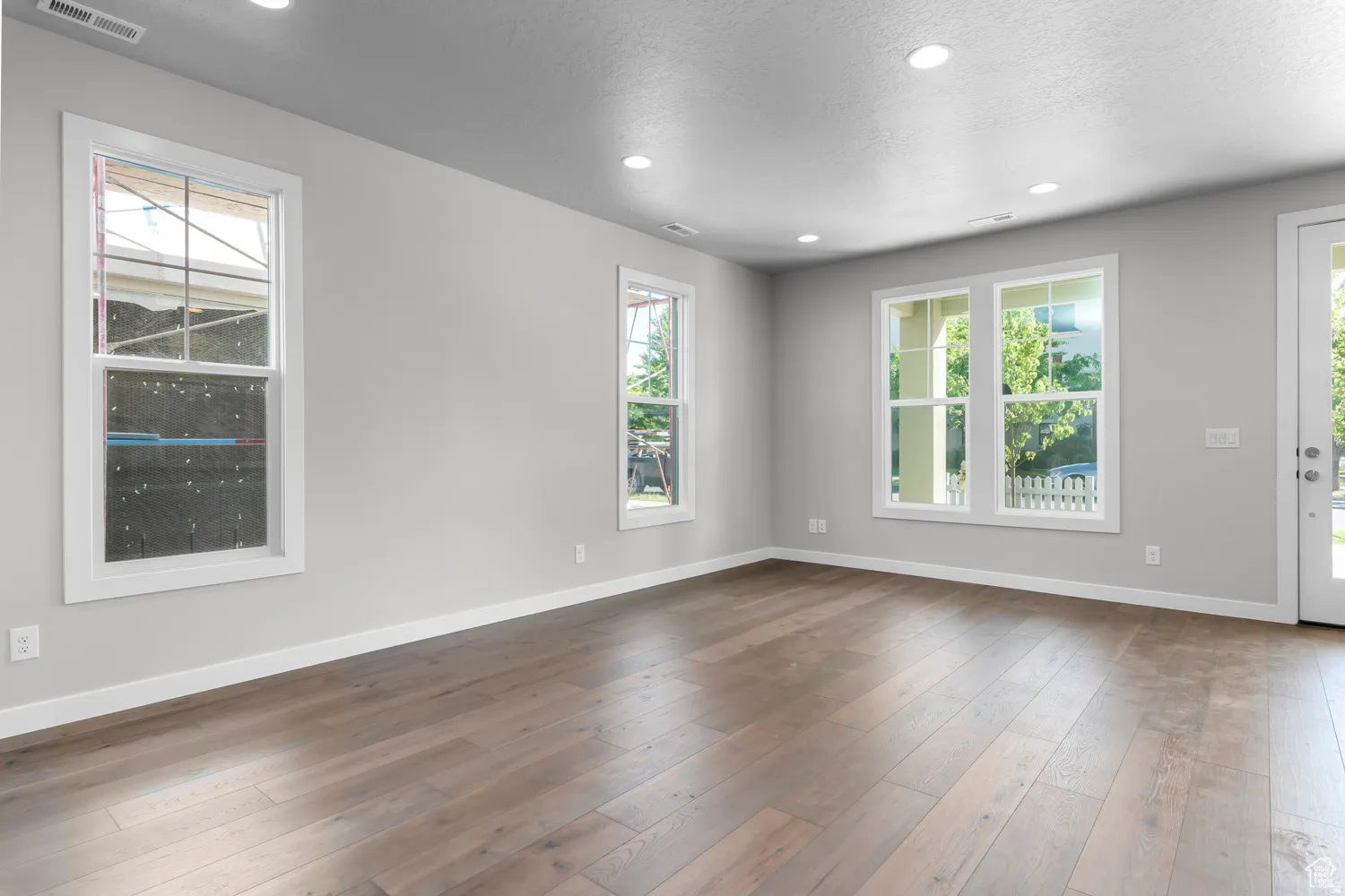Unfurnished room with recessed lighting, dark wood-style floors, and a textured ceiling