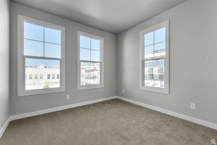 Empty room with carpet flooring and baseboards