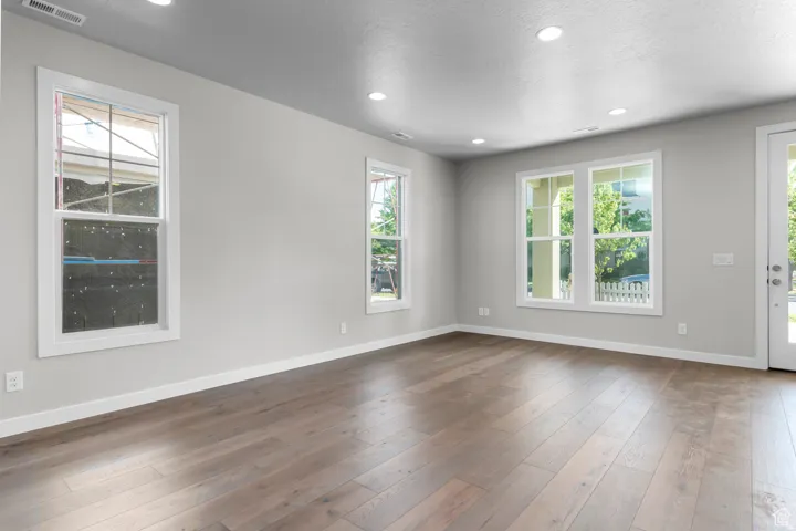 Unfurnished room with recessed lighting, dark wood-style floors, and a textured ceiling