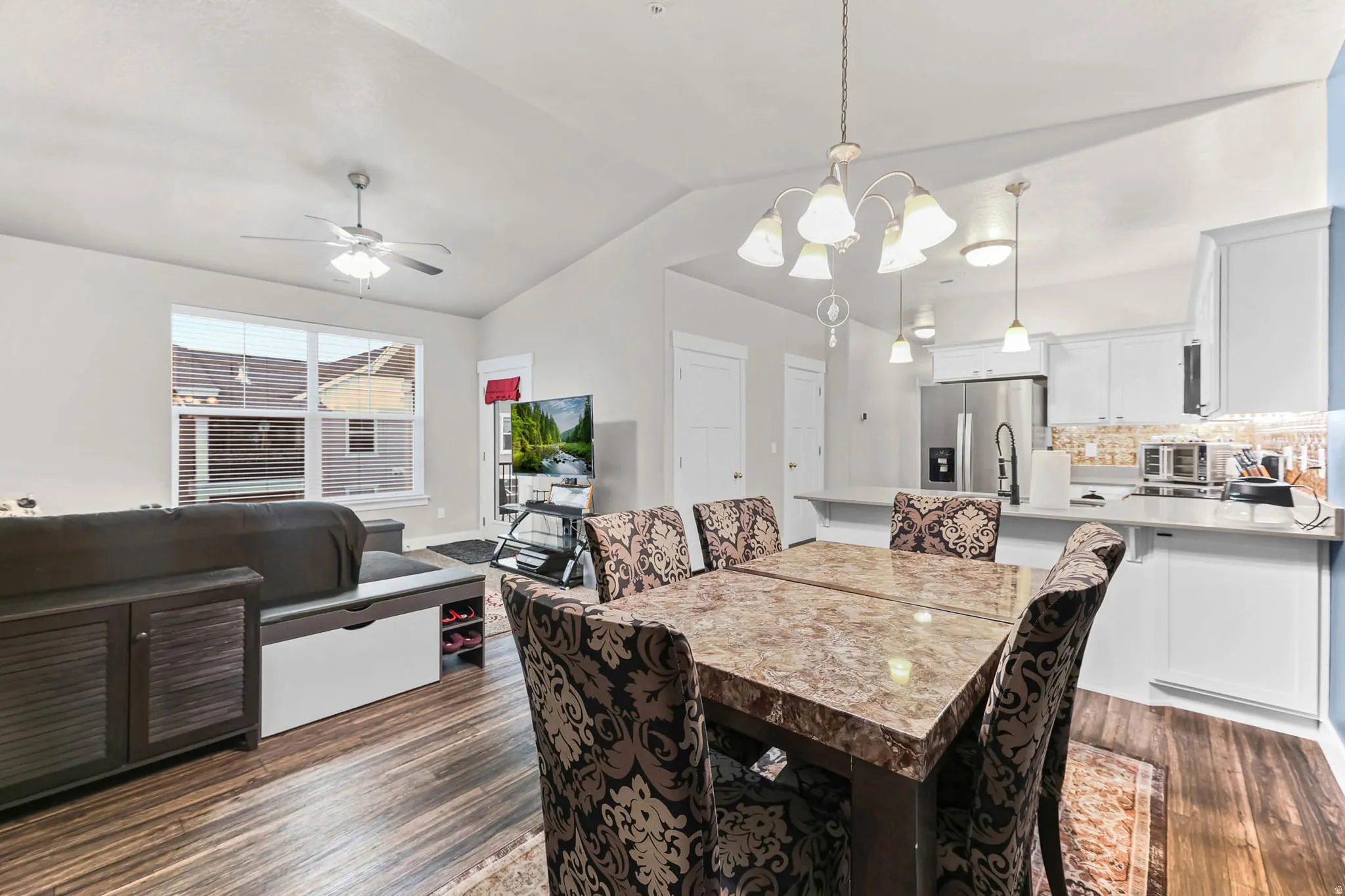 Dining area featuring hanging lights, lofted ceiling, dark wood-style flooring, and a ceiling fan