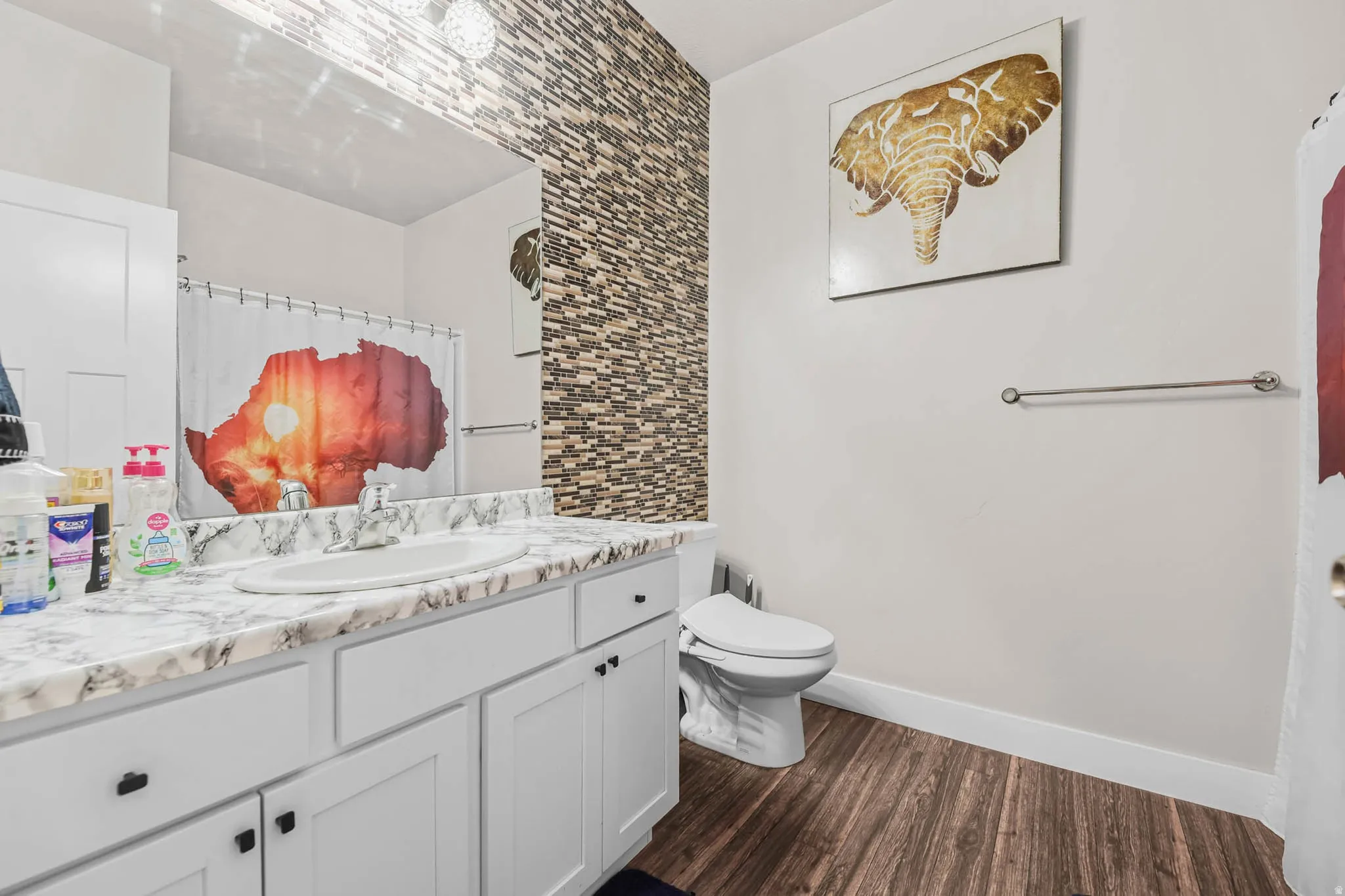 Full bath with vanity, curtained shower, and dark wood finished floors