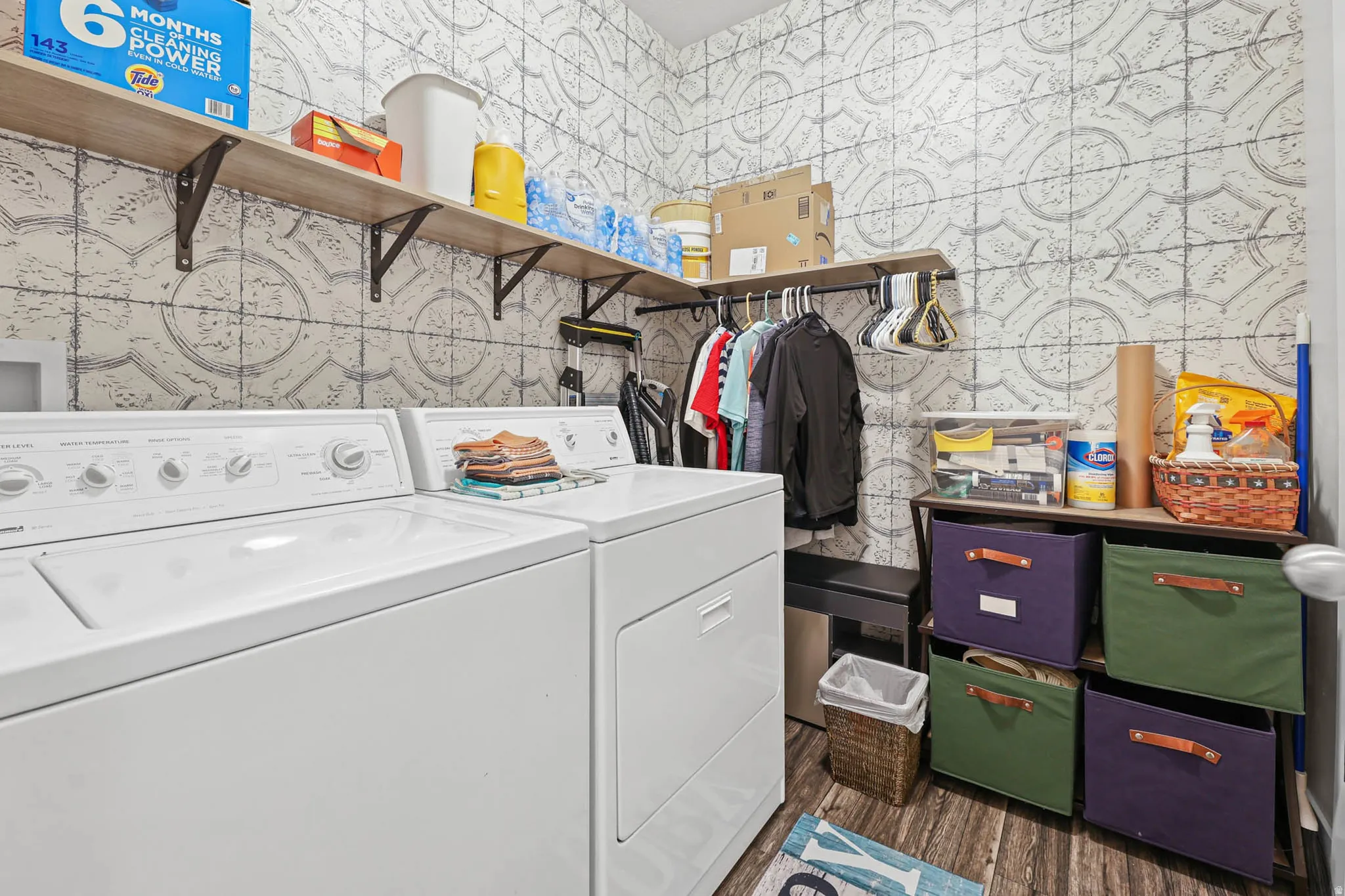 Laundry room featuring separate washer and dryer, dark wood-type flooring, and wallpapered walls