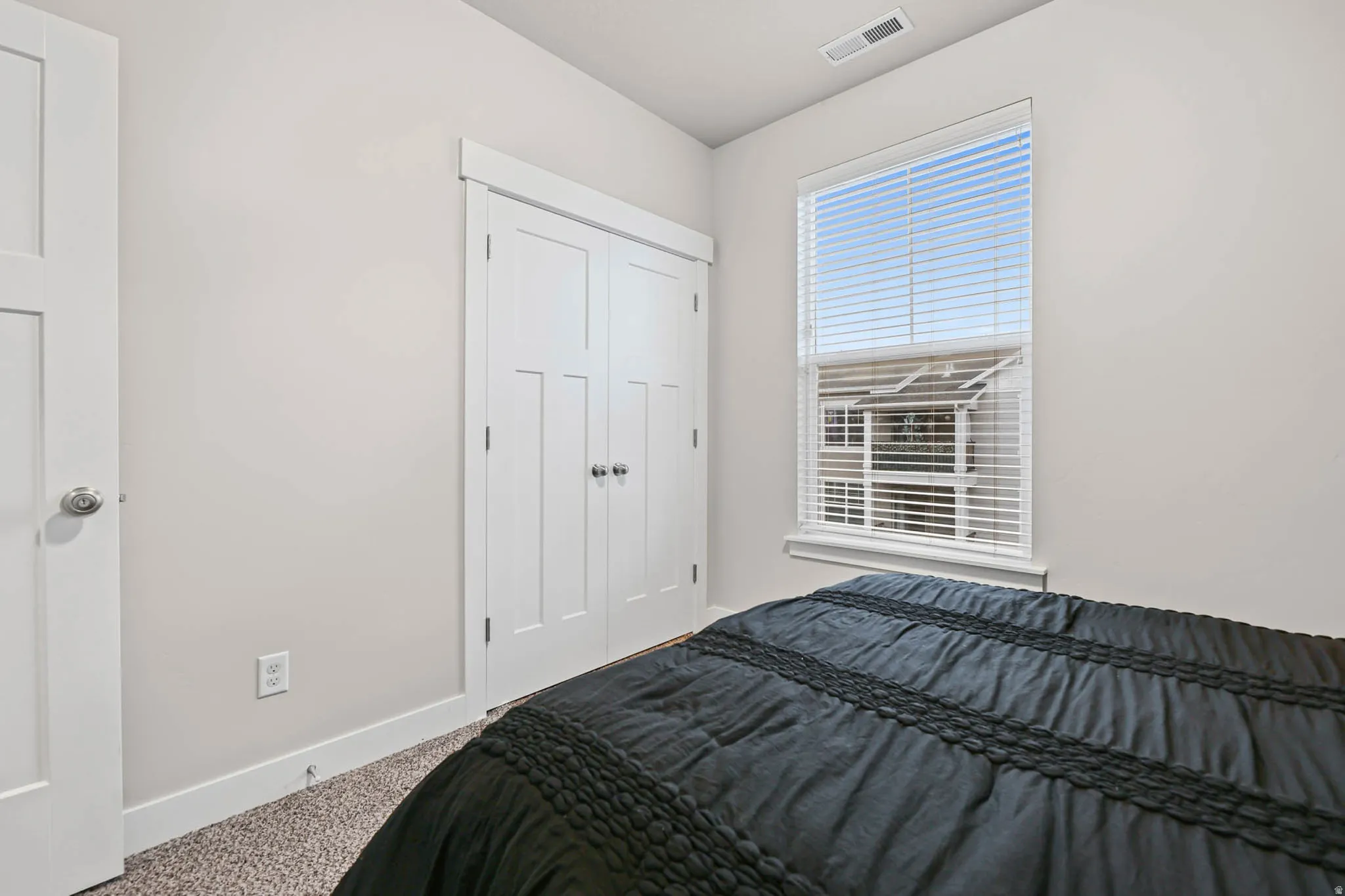 Carpeted bedroom featuring baseboards and a closet