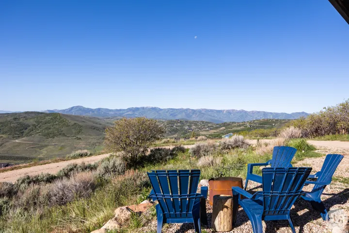 Outdoor seating area featuring a gravel surface, a rustic fire pit, and a natural wood stump table