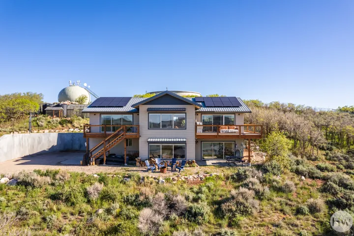 Contemporary two-story residence featuring light-toned siding and a dark roof