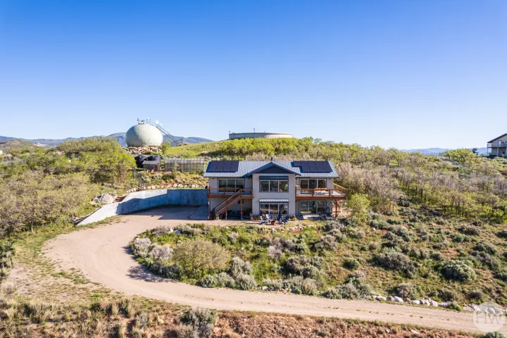 Hillside residence featuring a multi-level design and a gravel driveway