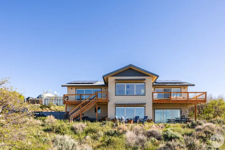 Contemporary two-story residence with a light-toned exterior siding and a dark-toned roof