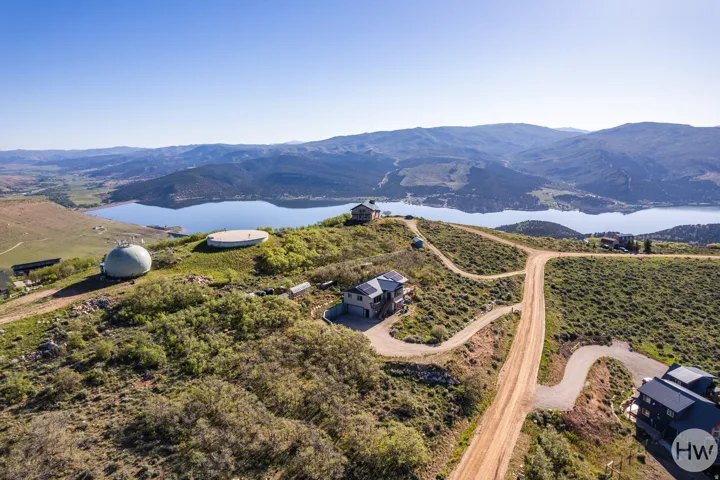 Expansive hillside property with lake backdrop and distant mountain range