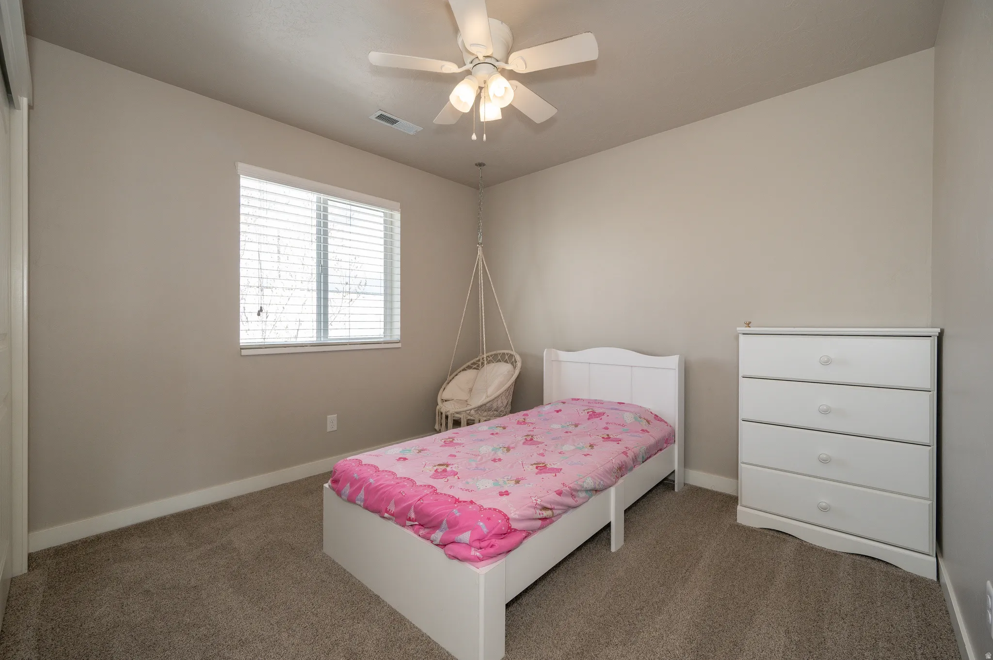 Carpeted bedroom featuring baseboards and a ceiling fan