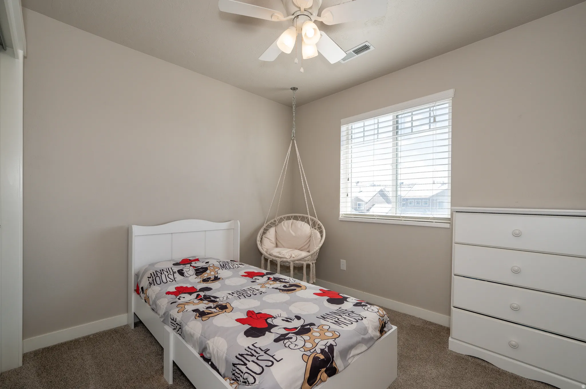 Carpeted bedroom featuring baseboards and a ceiling fan