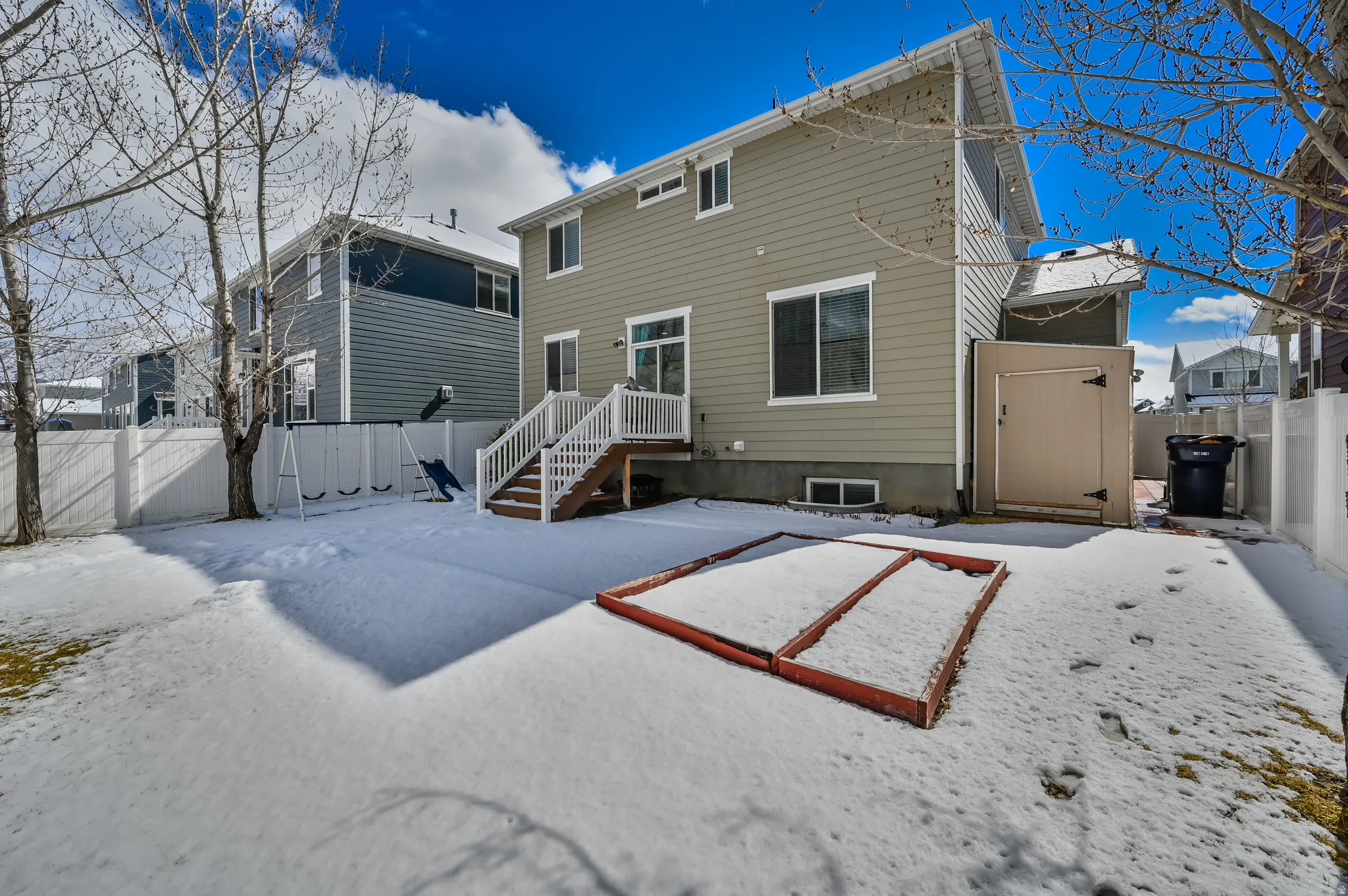 Snow covered rear of property featuring a fenced backyard