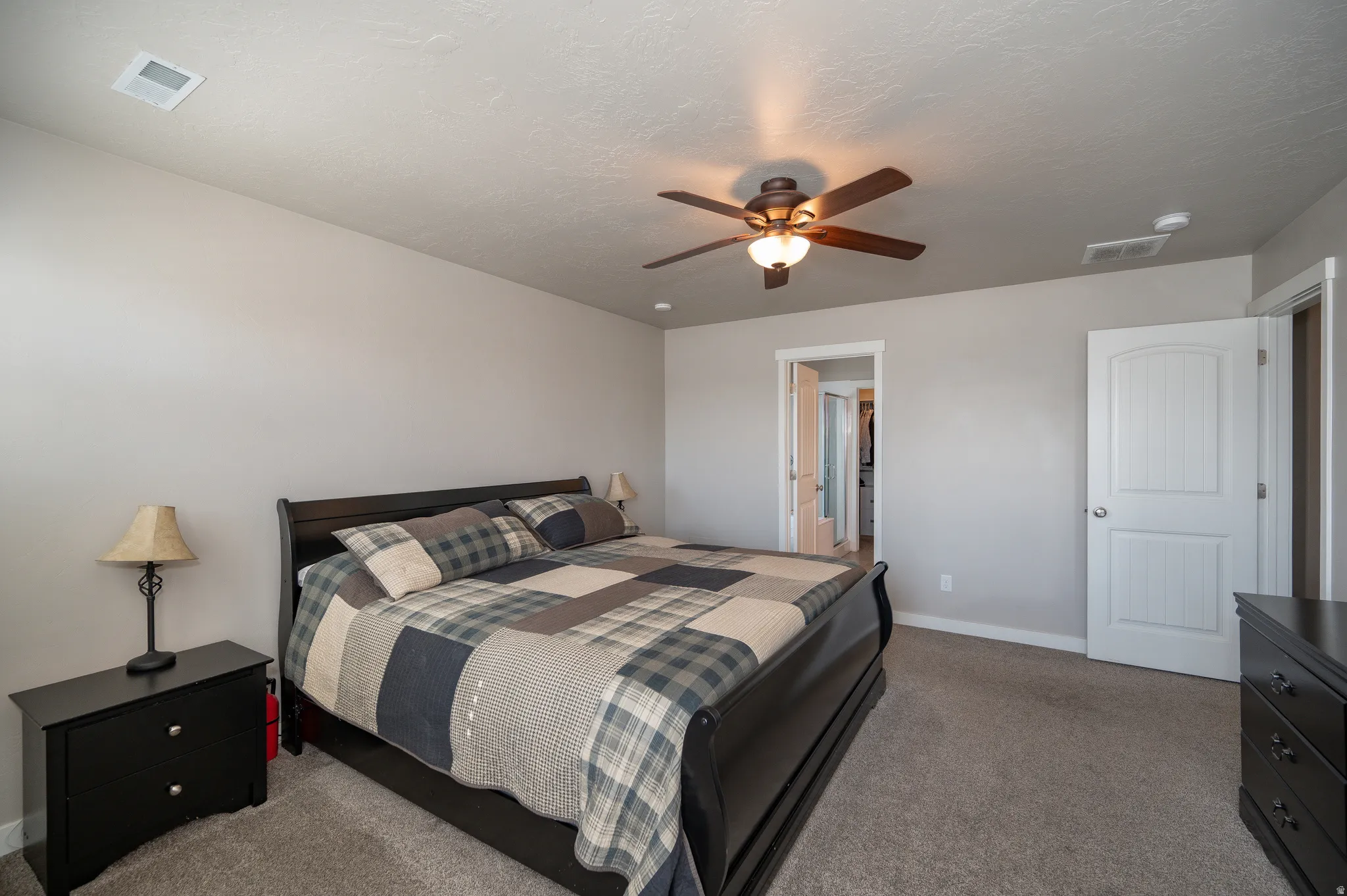 Bedroom featuring dark carpet and a ceiling fan