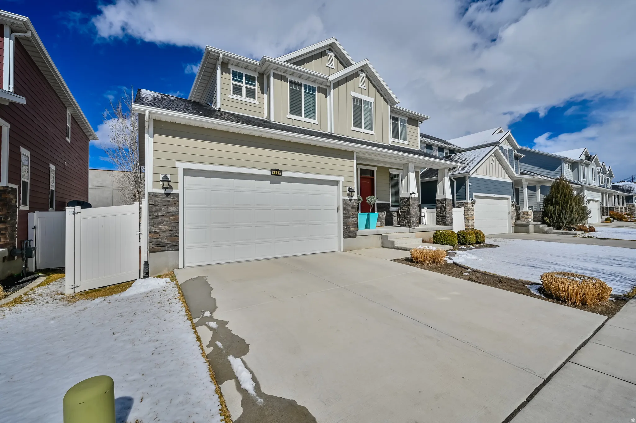 Craftsman house featuring board and batten siding, stone siding, a porch, and driveway