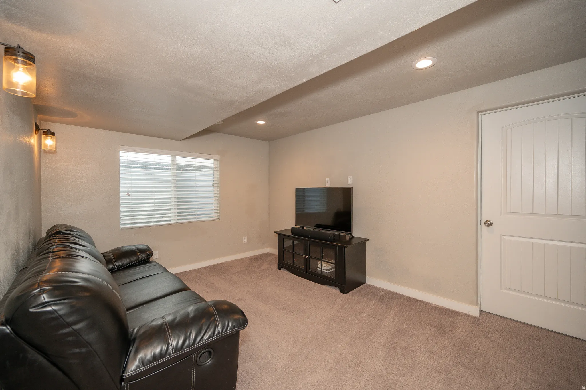Living room with light colored carpet and recessed lighting