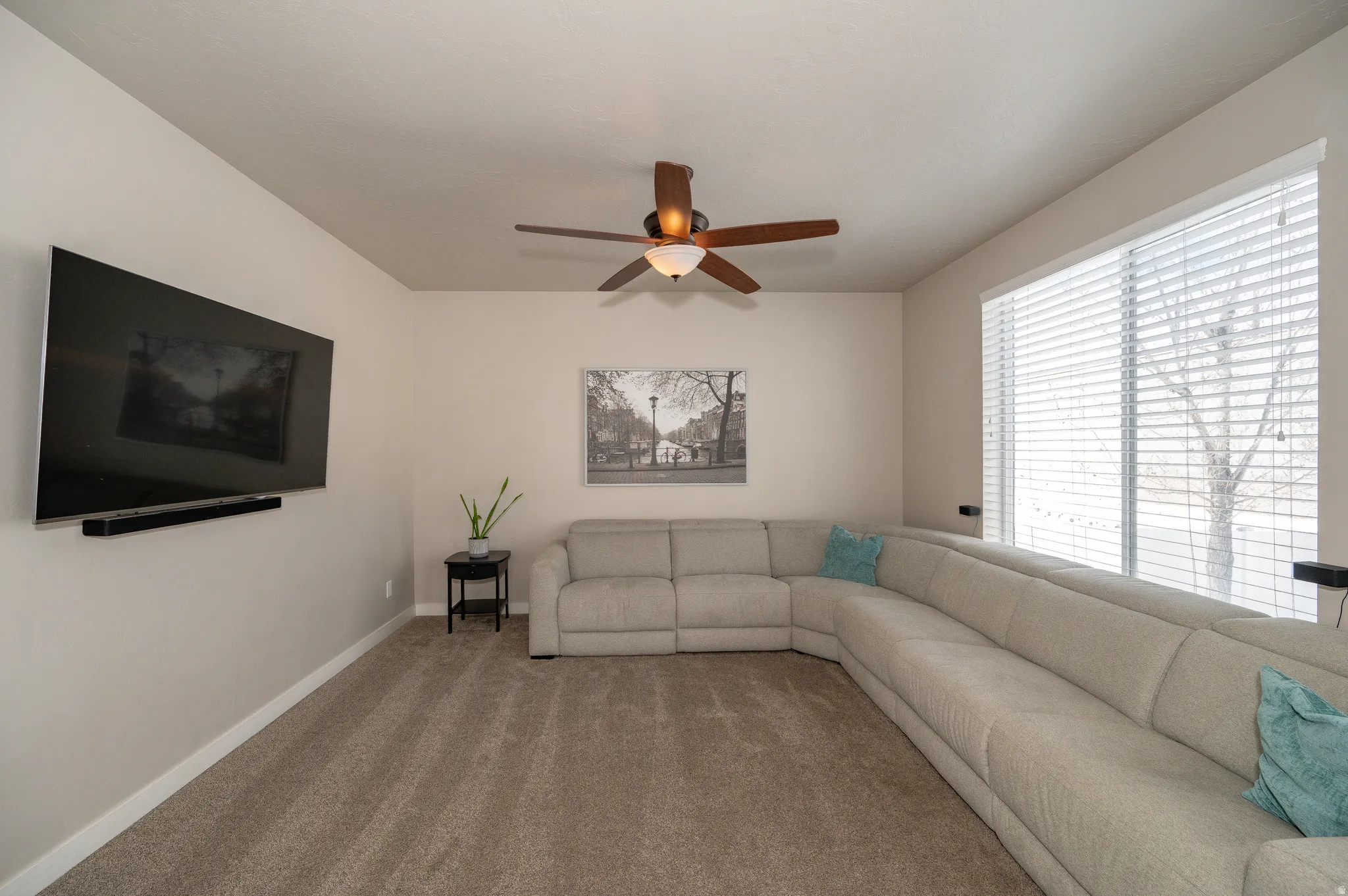 Living room featuring a ceiling fan and carpet floors