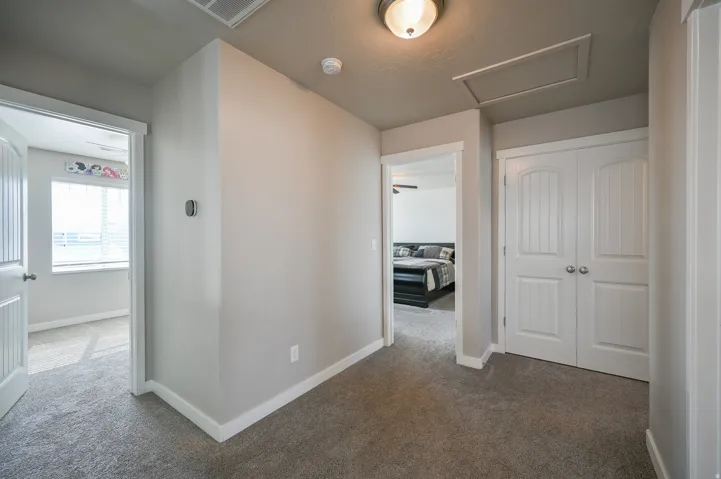 Hall featuring dark colored carpet