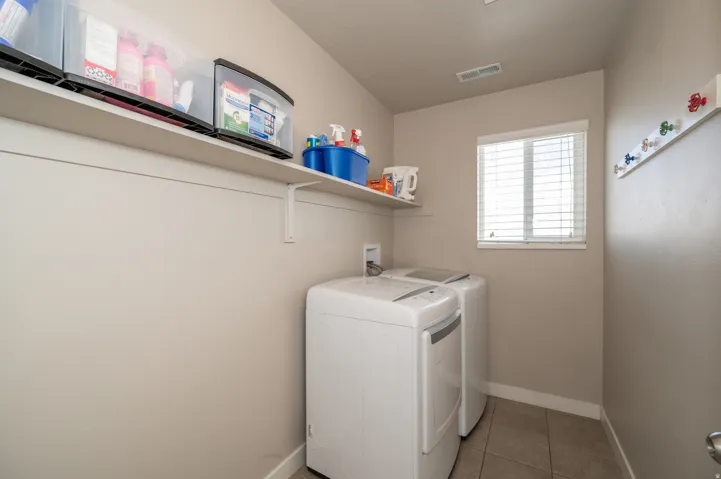 Laundry area with light tile patterned floors and washer and clothes dryer