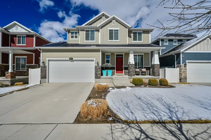 Craftsman inspired home featuring a porch, stone siding, driveway, and board and batten siding