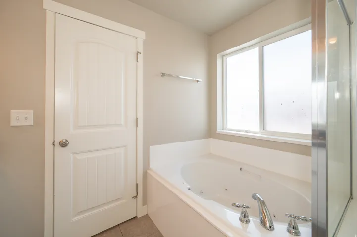Full bath with a tub with jets and light tile patterned floors